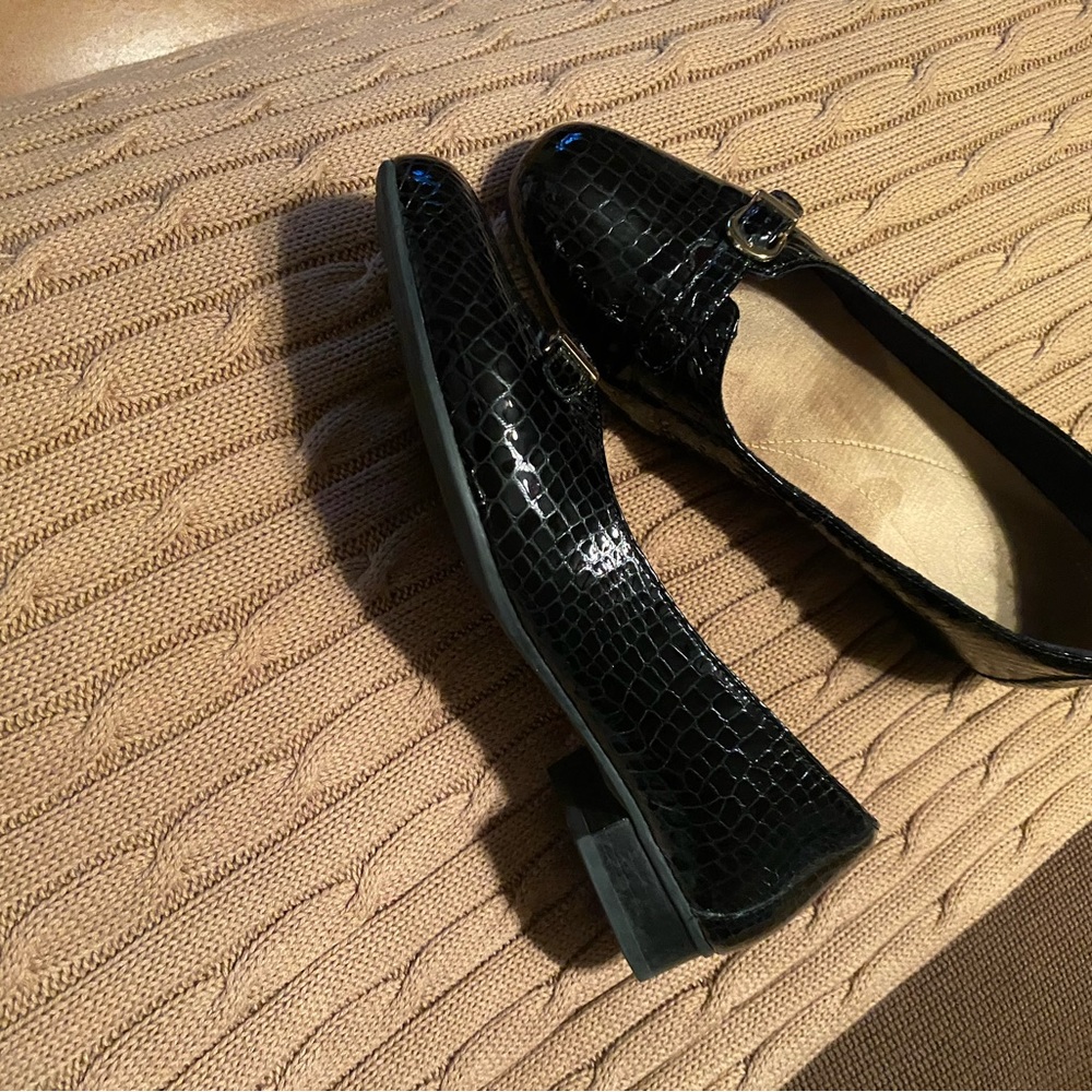 Clarks woman’s black loafers with gold hardware. Black embosssed leather